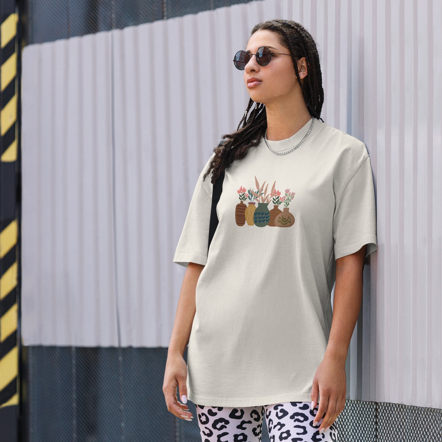 Woman wearing a faded bone oversized faded tee with an eclectic potted plants design, highlighting unique self-expression and vibrant fashion.