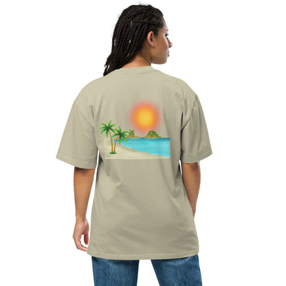 Woman in a faded eucalyptus oversized T-shirt with a vibrant beach sunset graphic.