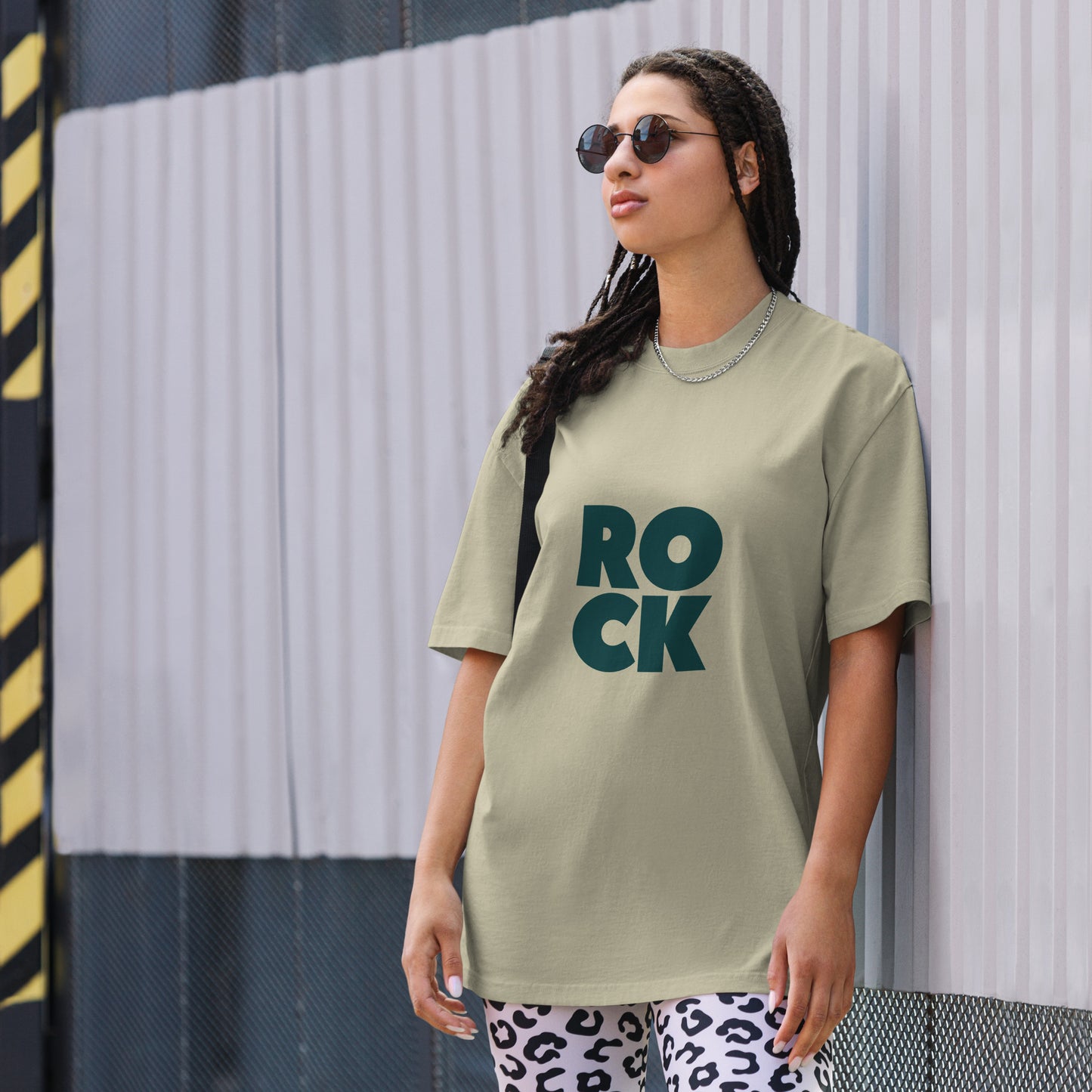 Confident individual rocking a bold faded eucalyptus oversized graphic tee with an oversized, faded ROCK design, embodying fearless self-expression.