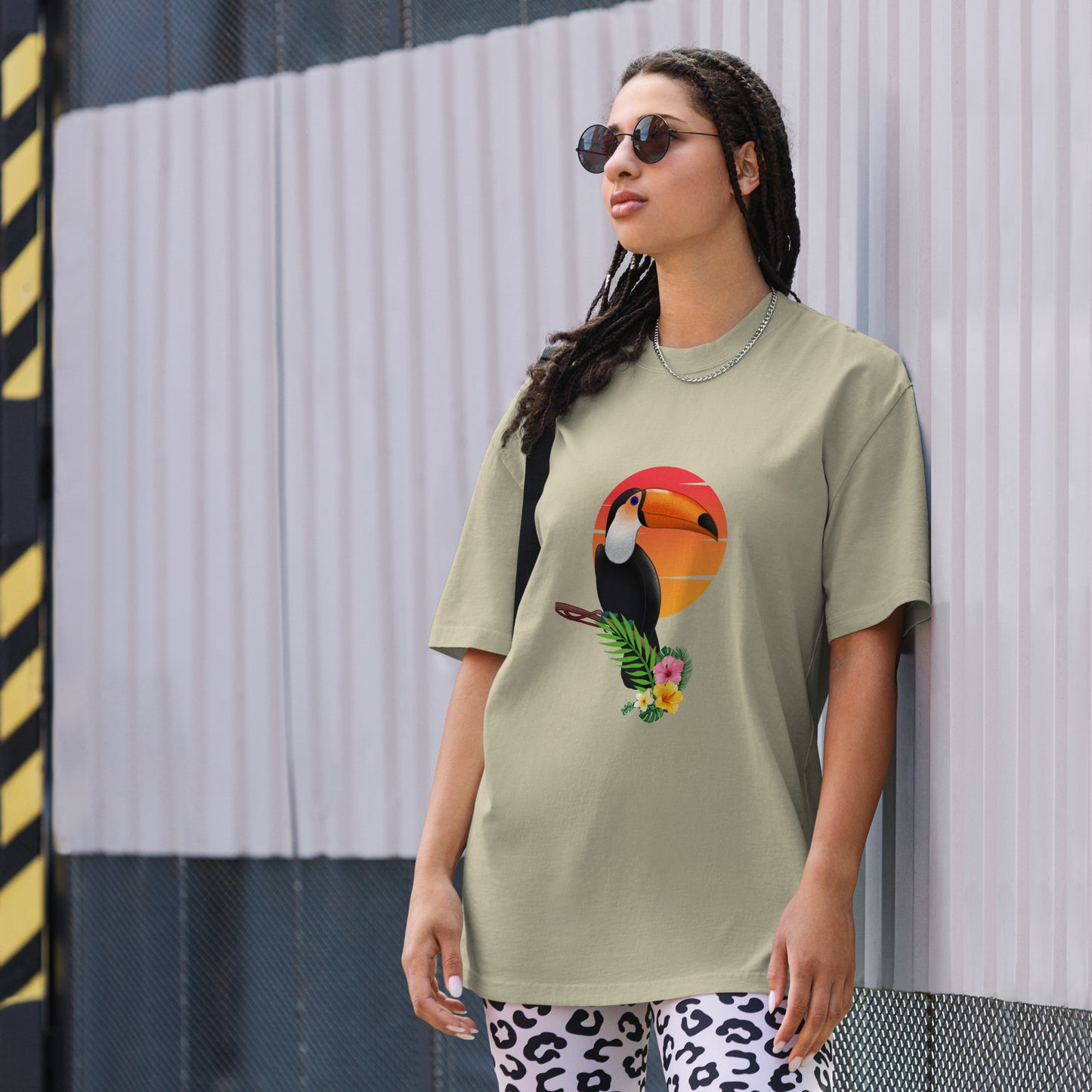 Woman in a faded eucalyptus oversized tee with colorful toucan graphic design, symbolizing vibrant self-expression.