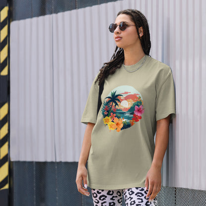 Fashion-forward woman in a Women's Tropical Sunset faded eucalyptus Oversized Tee featuring a vibrant, artistic print of palm trees and flowers, paired with statement leopard print pants and chic sunglasses, encapsulating a fresh, summery aesthetic.