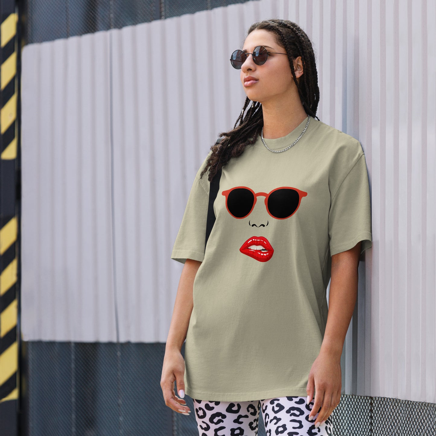 Woman wearing a Women's Quirky Retro Red Specs faded eucalyptus Oversized Graphic Tee, embodying cool self-expression with a touch of retro charm.