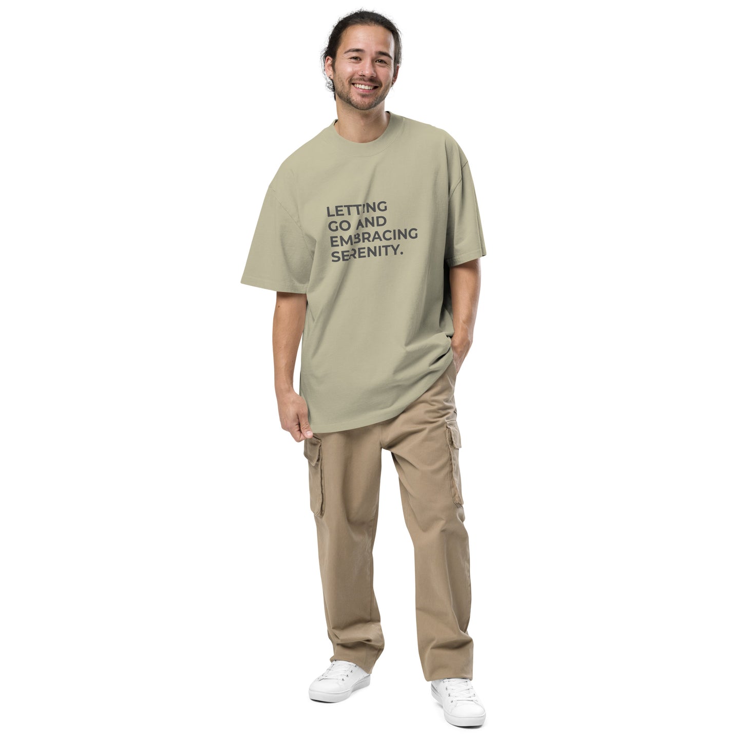 Man wearing a faded eucalyptus oversized faded tee in off-white with "Letting Go and Embracing Serenity" text. 