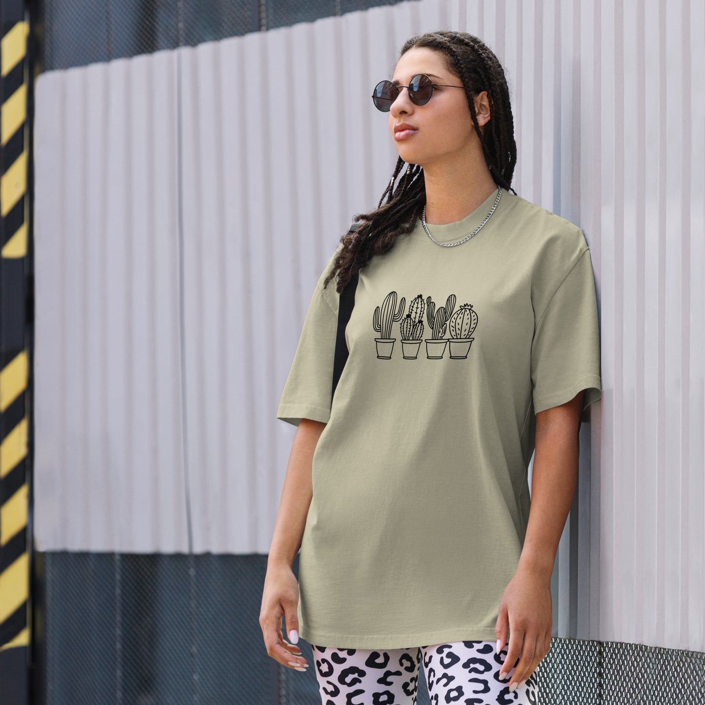 Woman wearing a faded eucalyptus oversized faded tee with a charming cactus design, showcasing unique self-expression and quirky elegance.