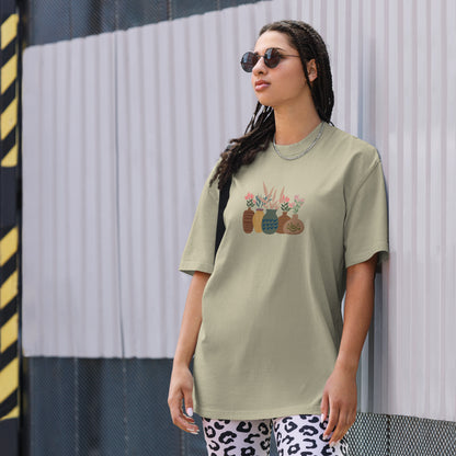 Woman wearing a faded eucalyptus oversized faded tee with an eclectic potted plants design, highlighting unique self-expression and vibrant fashion.