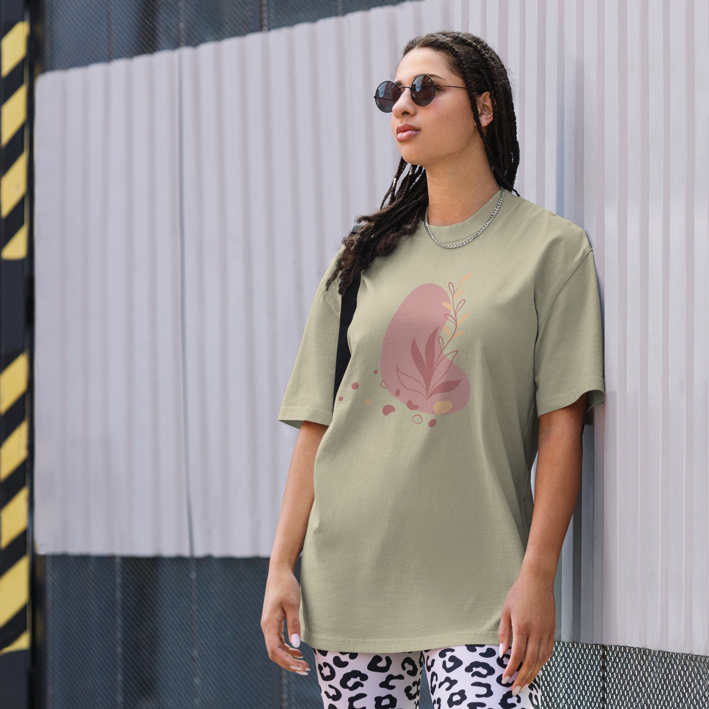 Woman wearing a eucalyptus oversized faded tee with a bold heart design, showcasing self-expression and fearless fashion