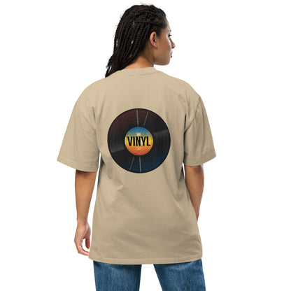 Woman from the back wearing a Be You Out Loud faded khaki oversized tee with a colorful vinyl record design, merging classic charm with modern fashion.