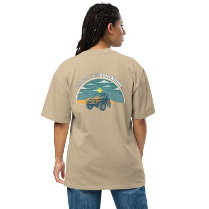 Woman showcasing Women's Quirky Adventure faded khaki Oversized Graphic Tee with retro jeep design, ideal for those who love a dash of whimsy on their adventures.