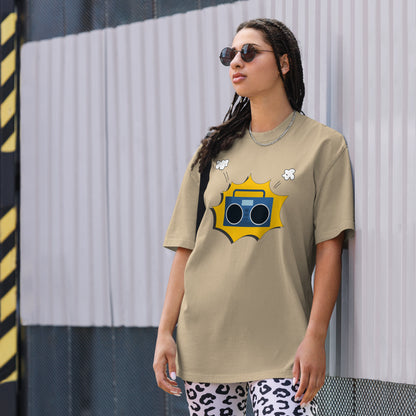 Woman in a faded khaki oversized tee with a vibrant yellow retro mixtape graphic, combining classic style with a punch of personality for any casual occasion.