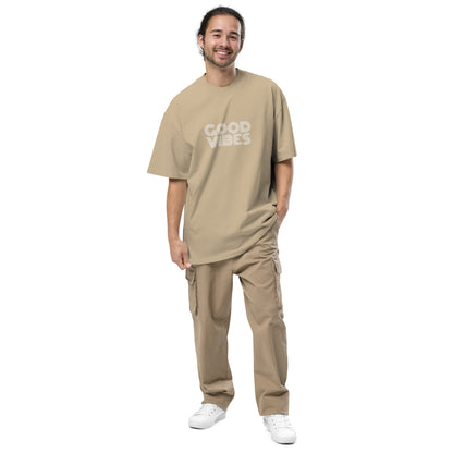 Smiling man in Men's "Good Vibes Only" faded khaki Oversized Tee by Be You Out Loud, embodying positivity and self-expression.