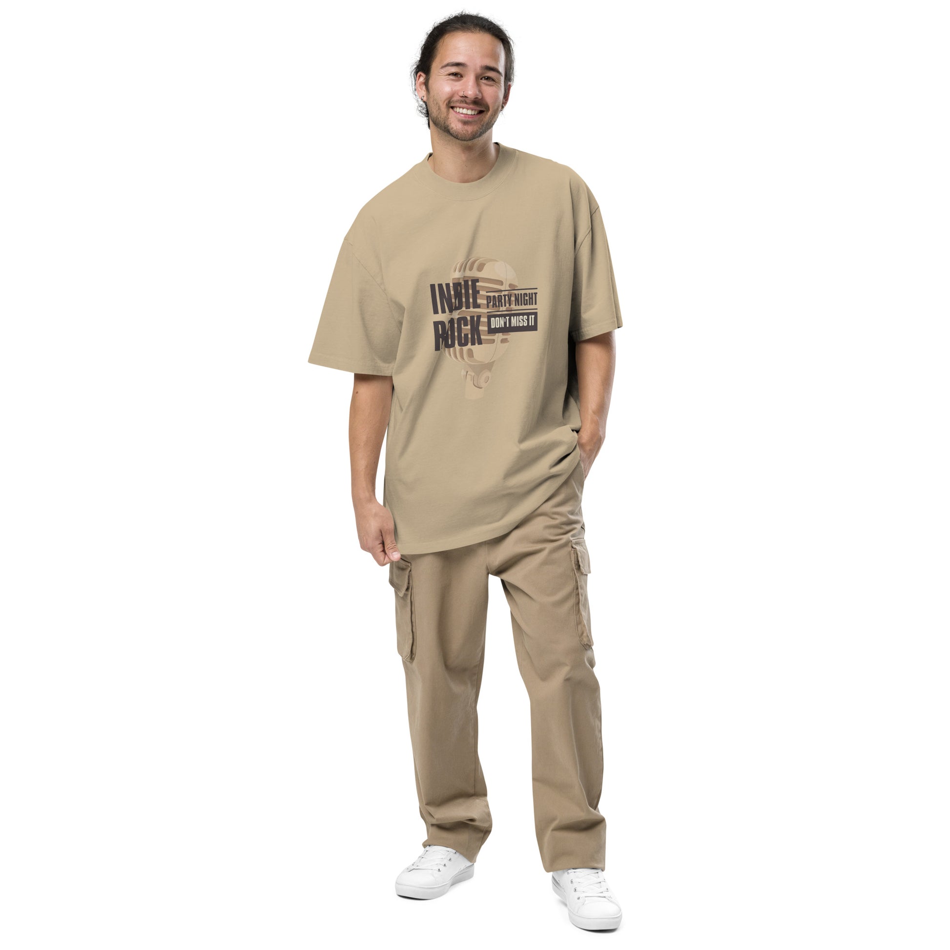 Smiling man in Men's "Indie Night Rich" faded khaki Oversized Graphic Tee in khaki, perfect for partygoers and indie music lovers.