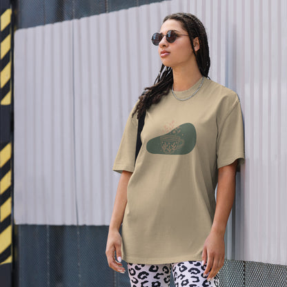 Woman wearing a faded khaki oversized faded tee with a whimsical tea cup design, highlighting playful self-expression and bold fashion.