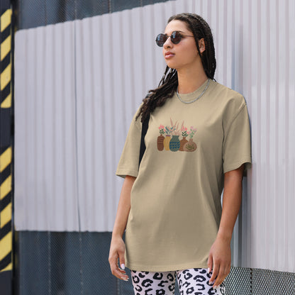 Woman wearing a faded khaki oversized faded tee with an eclectic potted plants design, highlighting unique self-expression and vibrant fashion.