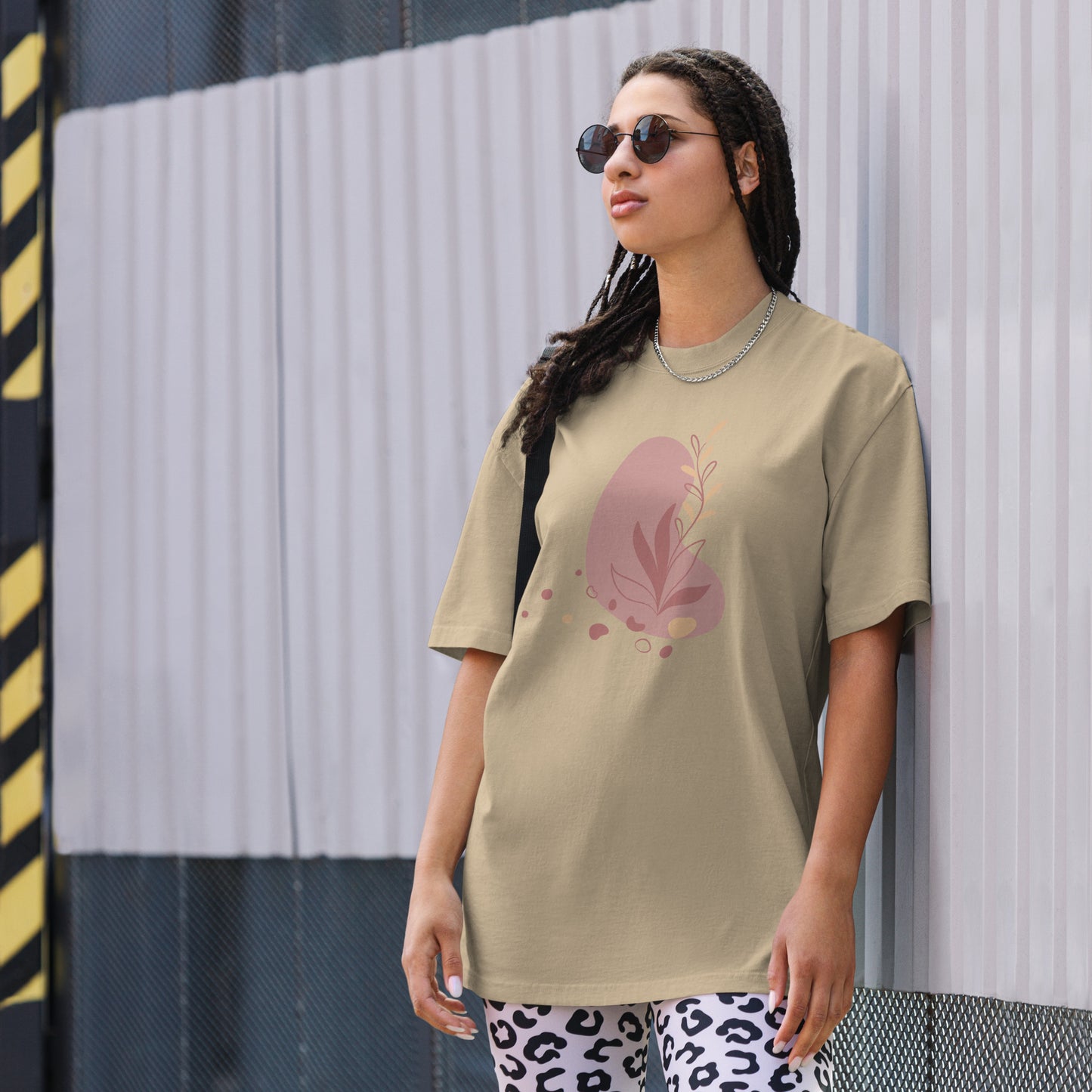 Woman wearing a khaki oversized faded tee with a bold heart design, showcasing self-expression and fearless fashion