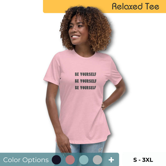 Confident woman with curly hair wearing a relaxed fit light pink tee with the inspirational message 'Be Yourself' repeated in dark letters, available in multiple colors, sizes S-3XL