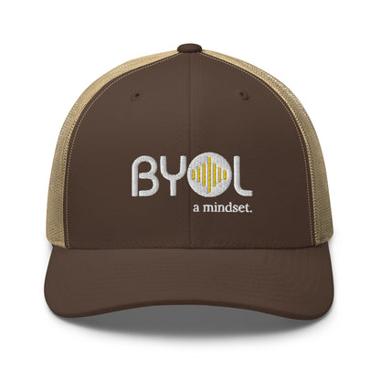 Brown and khaki retro trucker hat with "BYOL a mindset" embroidered on the front in gray and yellow, displayed against a clean background. Available in various colors: black, white, brown, green, and beige.