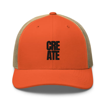 Orange and light brown trucker cap with "CREATE" embroidered in black on the front, featuring a mesh back and adjustable strap.