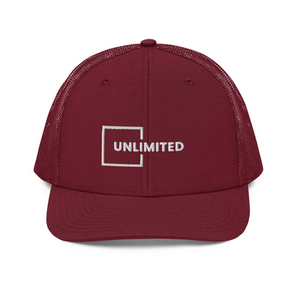 A maroon snapback trucker cap featuring the word "UNLIMITED" in white block letters enclosed within a white line square, embroidered on the front panel. The cap has a pre-curved visor, structured crown, breathable mesh panels on the sides and back, and an adjustable snap closure for a comfortable fit.