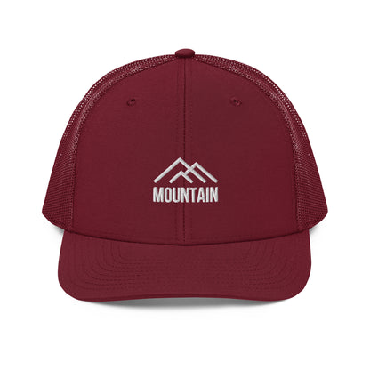 An maroon snapback trucker cap with a stylized white mountain range emblem above the word "MOUNTAIN," also in white, embroidered on the front panel. This cap features a curved visor, a structured front crown, mesh side and back panels for ventilation, and an adjustable snapback closure for a tailored fit.