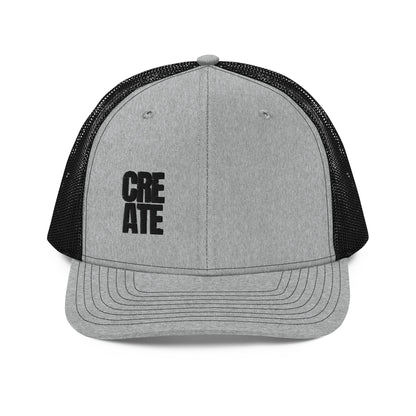 A grey and black snapback trucker cap with the word "CREATE" in bold black letters divided across the front panel. It features a pre-curved visor, a structured front crown, black mesh back panels for breathability, and an adjustable snap closure to fit various head sizes comfortably.