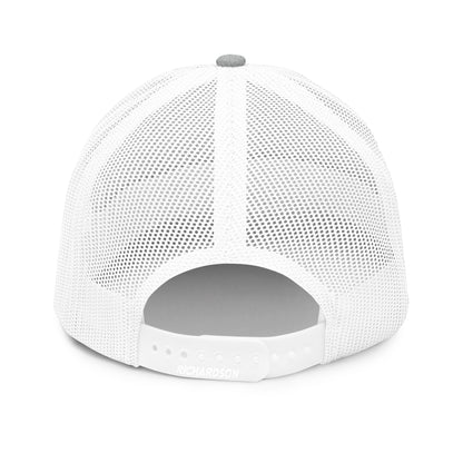 A rear view of a white snapback trucker cap, showcasing a mesh back for breathability and an adjustable plastic snap closure for a customizable fit. The cap has a gray underbill, and the brand "RICHARDSON" is embossed on the back panel above the snapback.