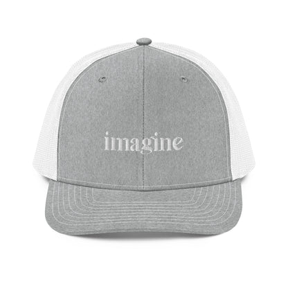 A grey and white snapback trucker cap with the word "imagine" embroidered in white cursive letters on the front panel. The hat features a curved visor, structured front panels, and breathable mesh on the sides and back, with an adjustable snap closure for a comfortable, customized fit.