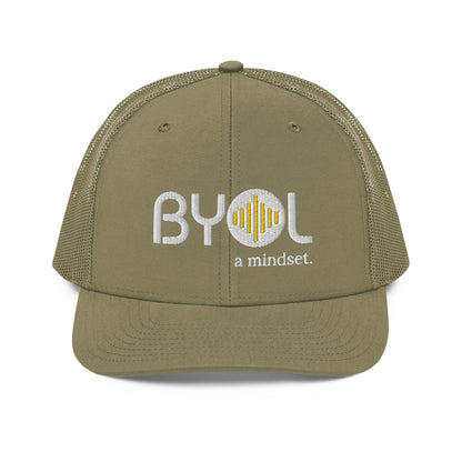 Military green pre-curved contrast stitched trucker hat with "BYOL a mindset" embroidered on the front in white and yellow, displayed against a clean background. Available in various colors: maroon, black, green, and gray.