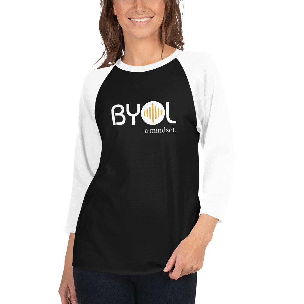 Woman wearing a black and white BYOL mindset raglan t-shirt with color options in red, gray, black, white, and green, available in sizes S to 3XL.