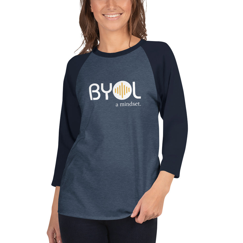 Woman wearing a heathered navy blue and solid navy blue BYOL mindset raglan t-shirt with color options in red, gray, black, white, and green, available in sizes S to 3XL.