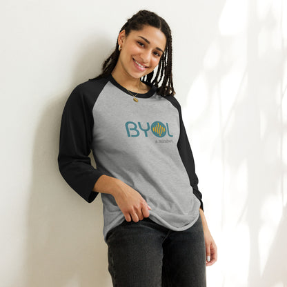 Woman wearing a heather grey and black BYOL mindset raglan t-shirt with color options in red, black, gray, and green, available in sizes S to 3XL.