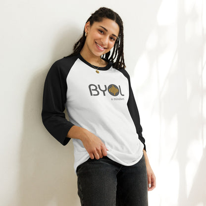 Woman wearing a white and black BYOL mindset raglan t-shirt with color options in red, black, white, and green, available in sizes S to 3XL.