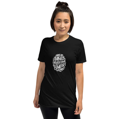 A woman with a confident stance is wearing a black t-shirt featuring the motivational quote "Great things never come from comfort zones" in white stylized text, inspiring action and bravery.