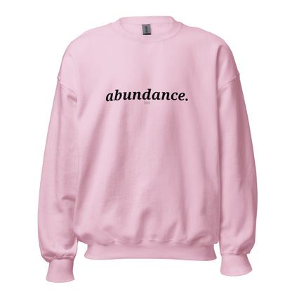 Pink sweatshirt with the phrase "abundance." printed on the front, available in color options navy blue, green, maroon, gray, and pink, available in sizes S to 3XL.