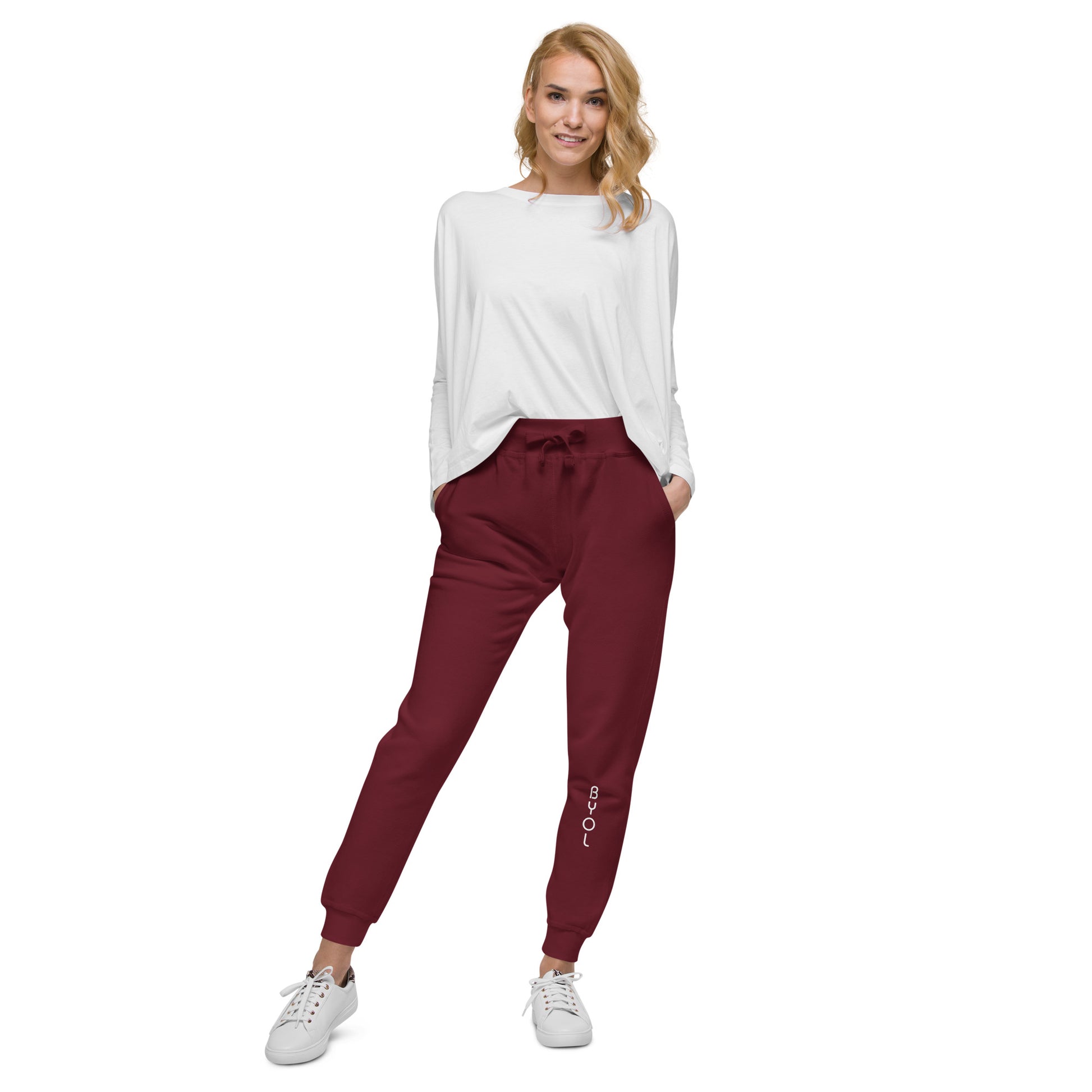 Woman wearing BYOL mindset joggers in maroon with color options in brown, olive green, pink, and white, available in sizes S to 3XL.