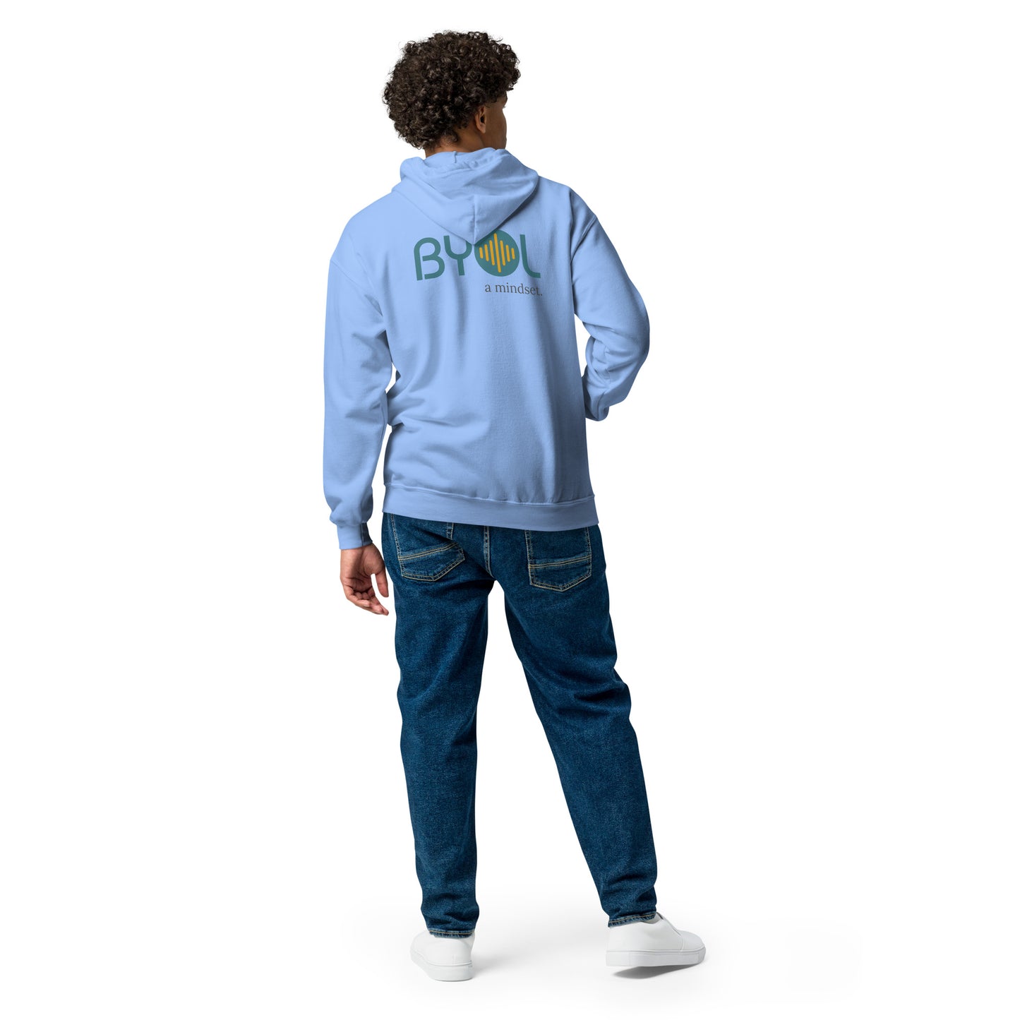 A young man with curly hair wearing a carolina blue "BYOL: a mindset" hoodie, viewed from the back. The hoodie features the "BYOL" logo in teal and yellow on the back and is available in multiple colors (black, gray, navy, white, plus more) and sizes (S-3XL). The "be you out loud" logo is displayed at the top.