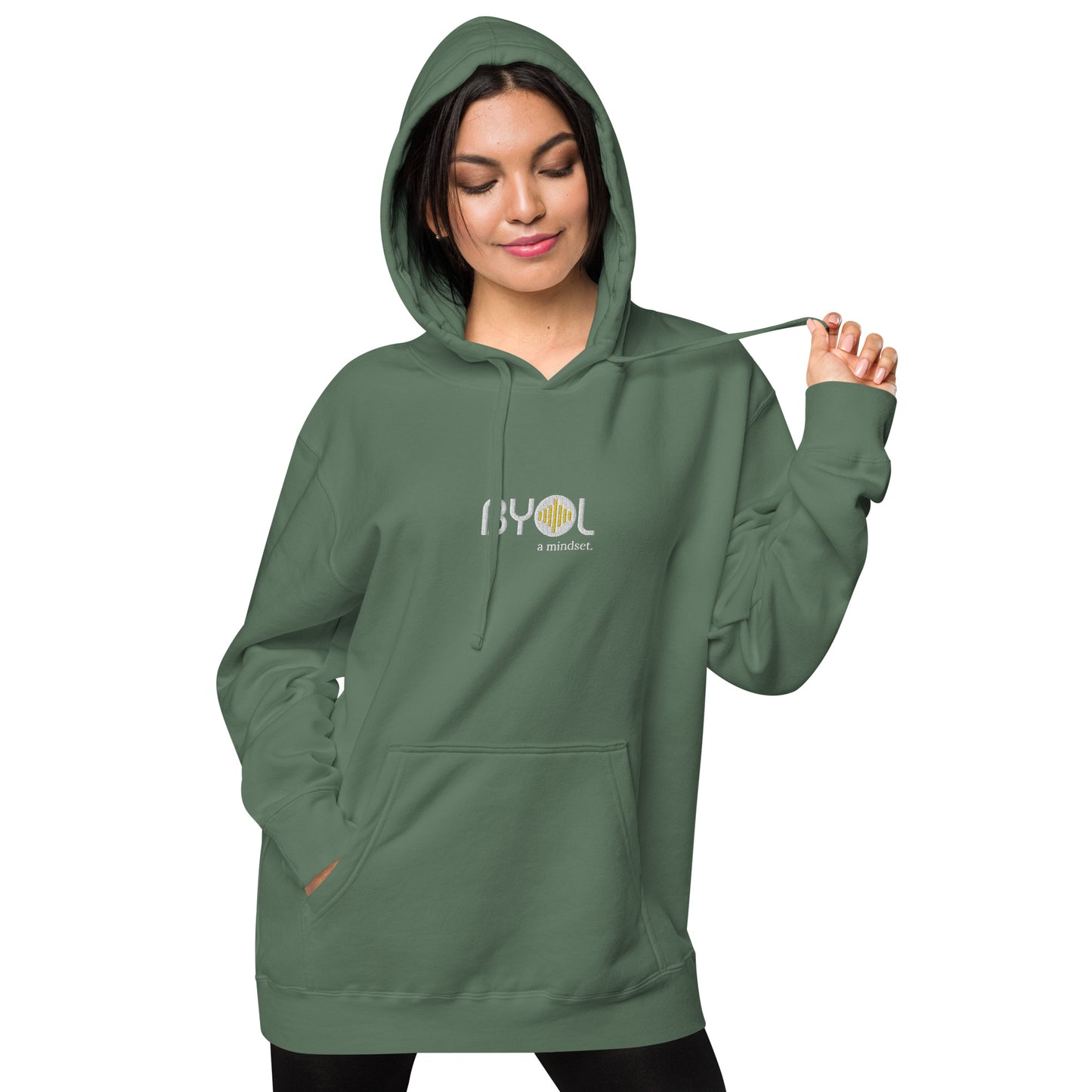 Woman wearing a pigmented green BYOL mindset hoodie with color options in brown, pink, gray, and green, available in sizes S to 2XL.