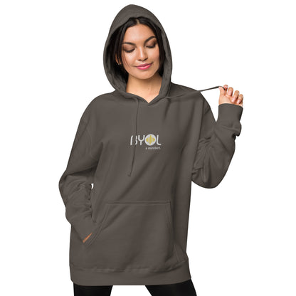 Woman wearing a pigmented black BYOL mindset hoodie with color options in brown, pink, gray, and green, available in sizes S to 2XL.