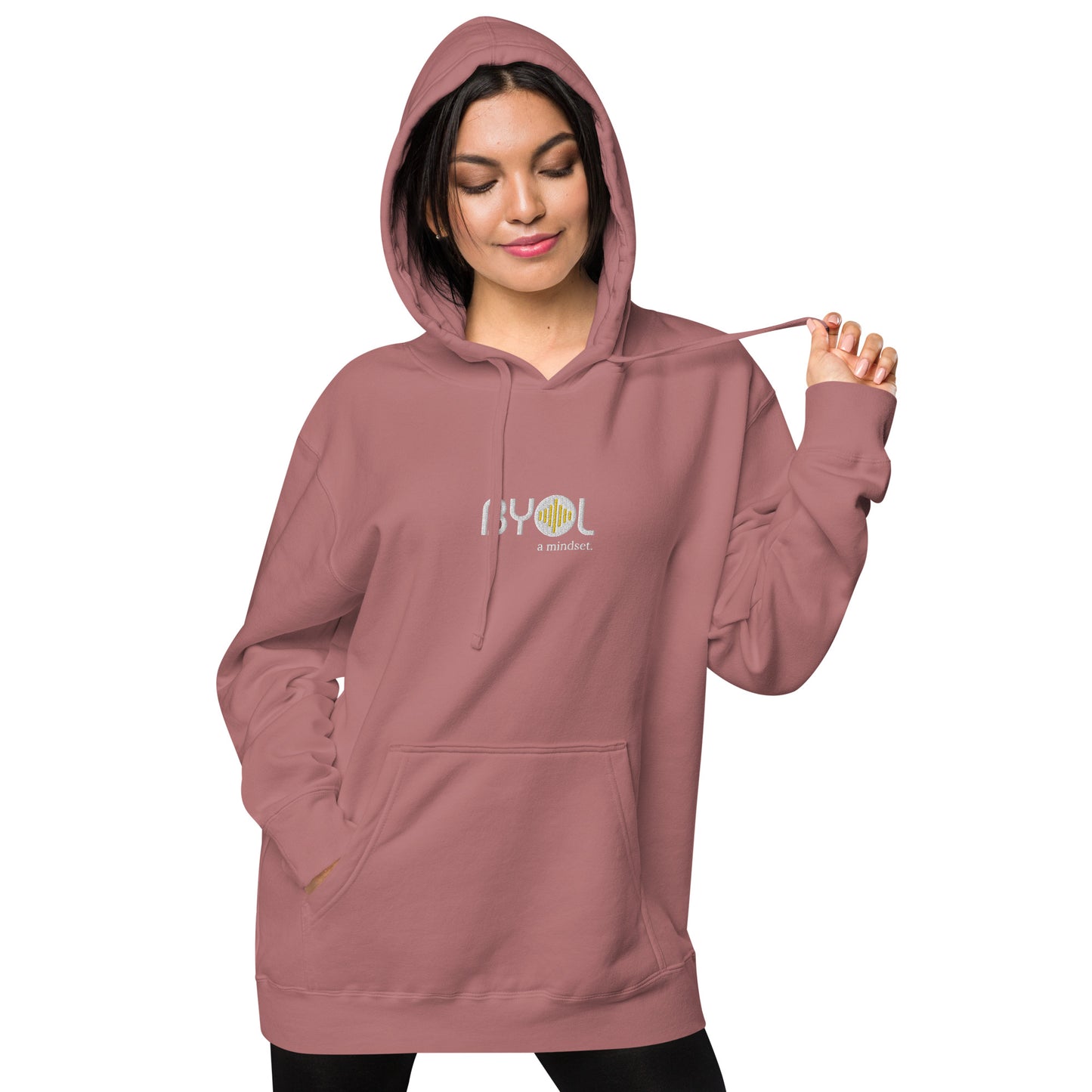 Woman wearing a pigmented pink BYOL mindset hoodie with color options in brown, pink, gray, and green, available in sizes S to 2XL.