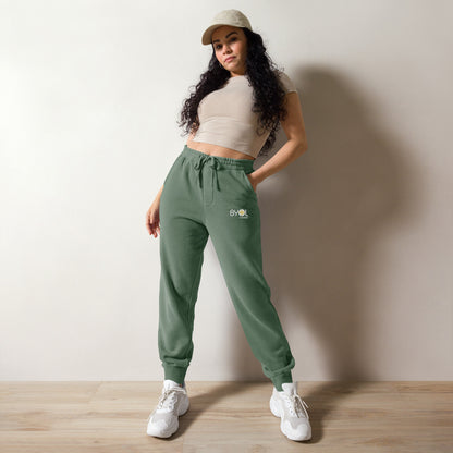 Close-up of a woman wearing pigment green BYOL mindset joggers with color options in brown, green, pink, and blue, available in sizes S to 3XL.