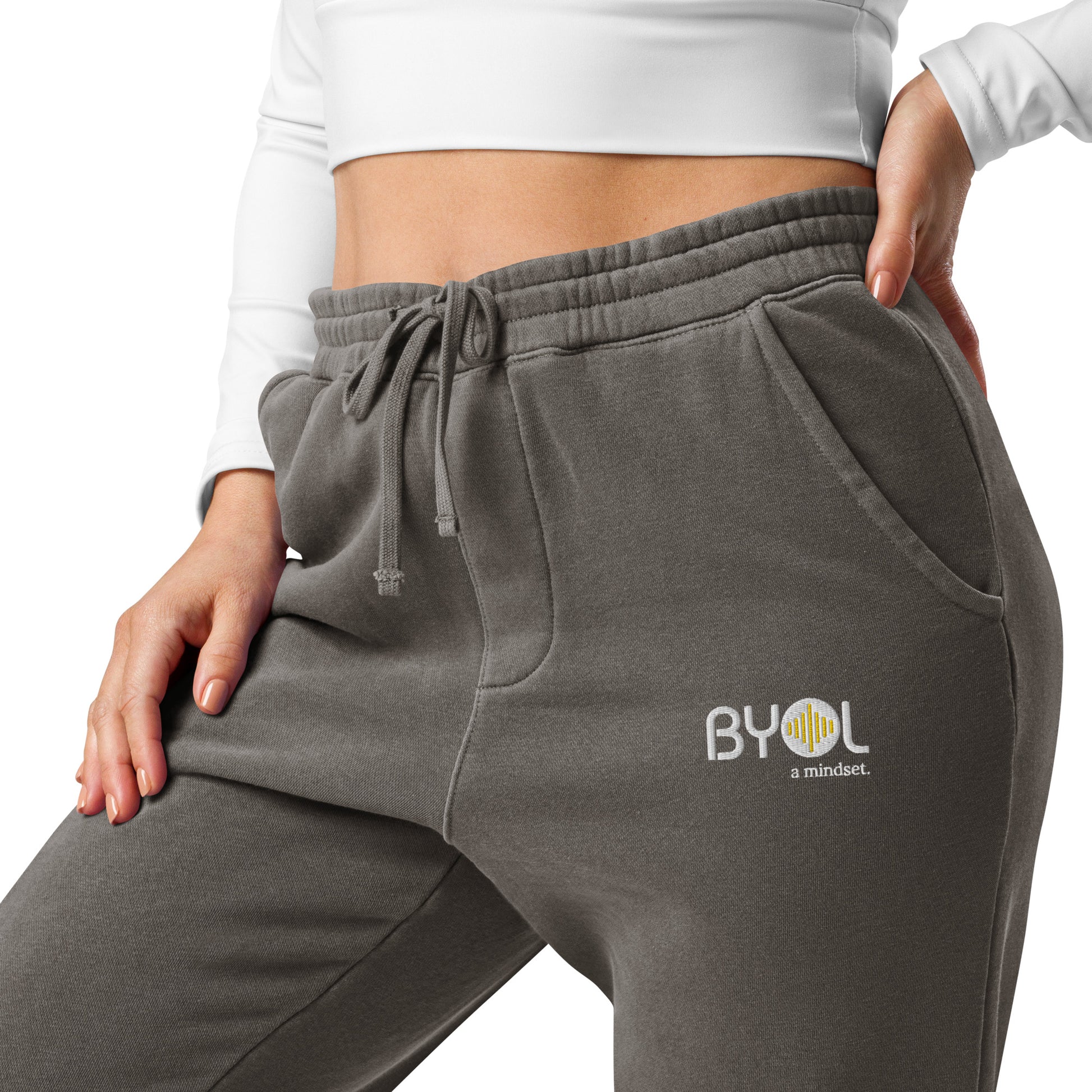 Close-up of a woman wearing pigment black BYOL mindset joggers with color options in brown, green, pink, and blue, available in sizes S to 3XL.