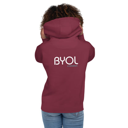 Back view of a woman wearing a maroon BYOL mindset hoodie with color options in black, maroon, dark gray, and light pink, available in sizes S to 3XL.