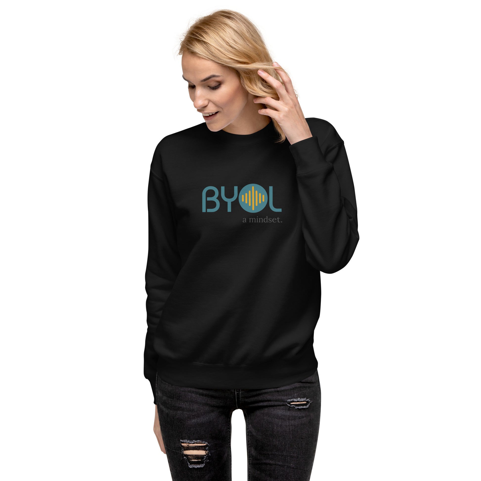 Woman wearing a black BYOL mindset sweatshirt with color options in black, dark gray, pink, and light gray, available in sizes S to 2XL.