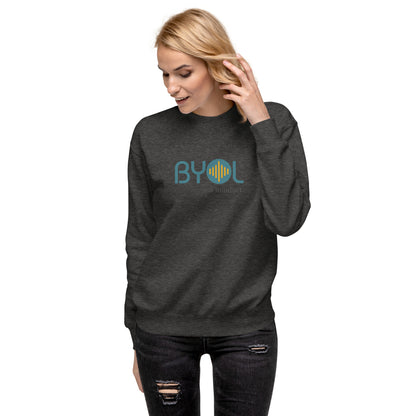 Woman wearing a charcoal heather BYOL mindset sweatshirt with color options in black, dark gray, pink, and light gray, available in sizes S to 2XL.