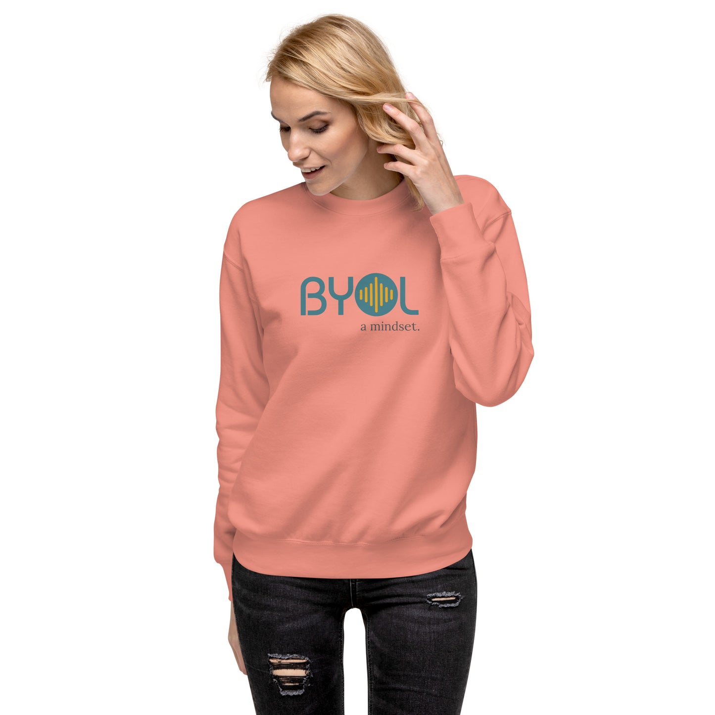 Woman wearing a dusty rose BYOL mindset sweatshirt with color options in black, dark gray, pink, and light gray, available in sizes S to 2XL.