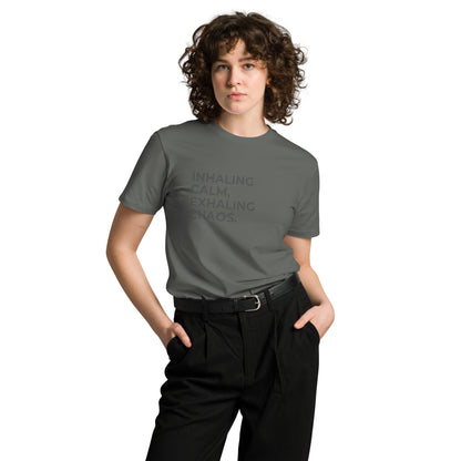 Woman wearing a charcoal premium tee with "Inhaling Calm, Exhaling Chaos" text.