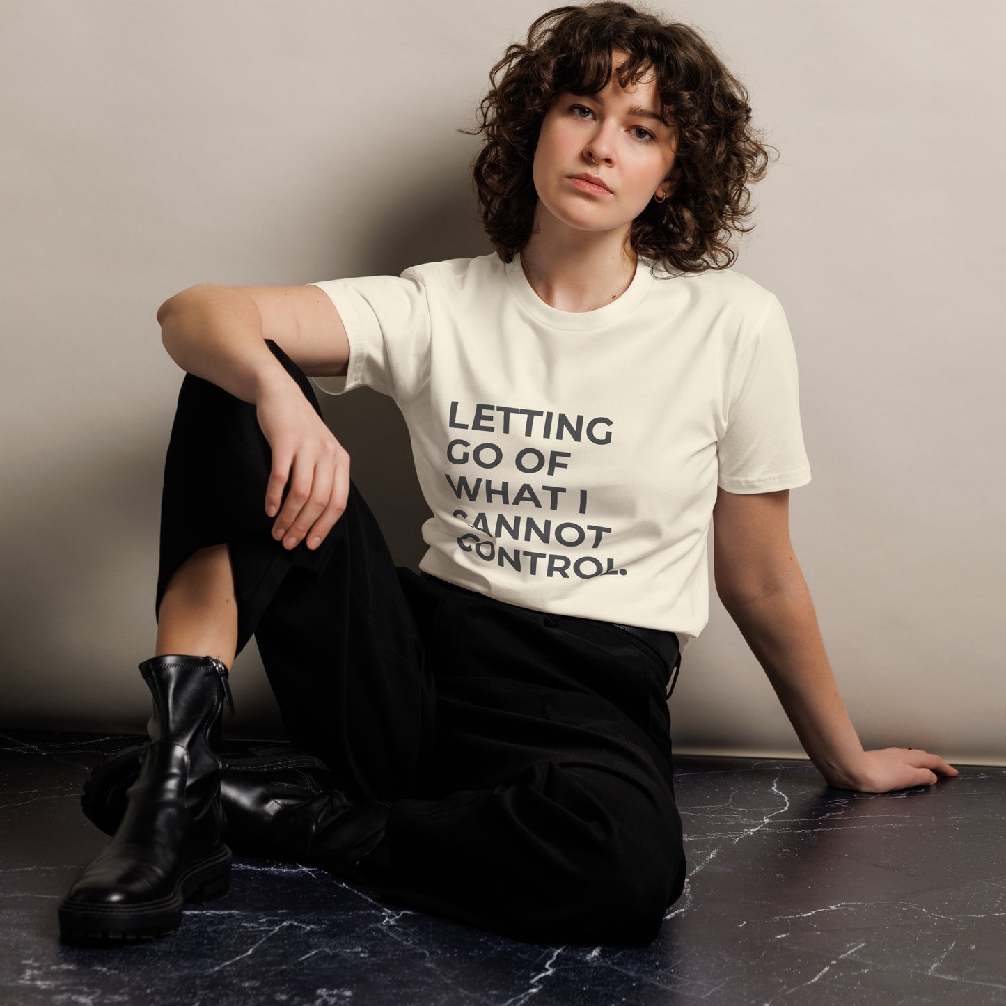 Woman wearing a naural premium tee with "Letting Go of What I Cannot Control" text.