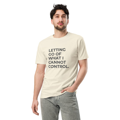 Man wearing a natural premium tee with the text "Letting Go of What I Cannot Control" in various colors and sizes from S to 2XL.