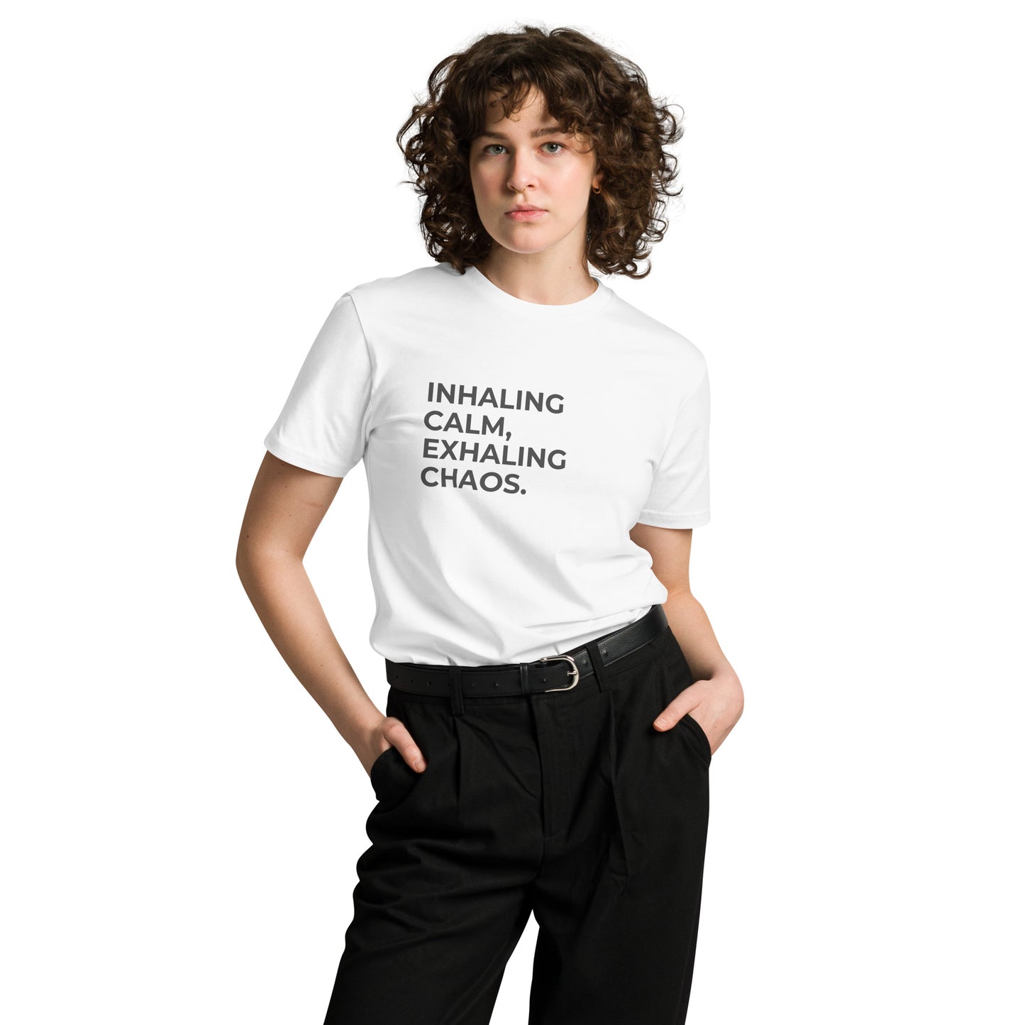 Woman wearing a white premium tee with "Inhaling Calm, Exhaling Chaos" text.