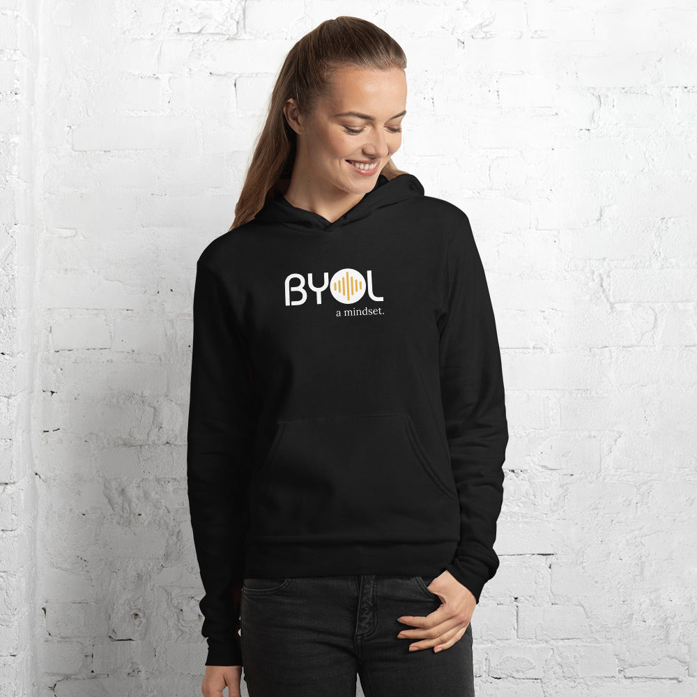 Woman wearing a black BYOL mindset hoodie with color options in black, navy blue, and gray, available in sizes S to 2XL.