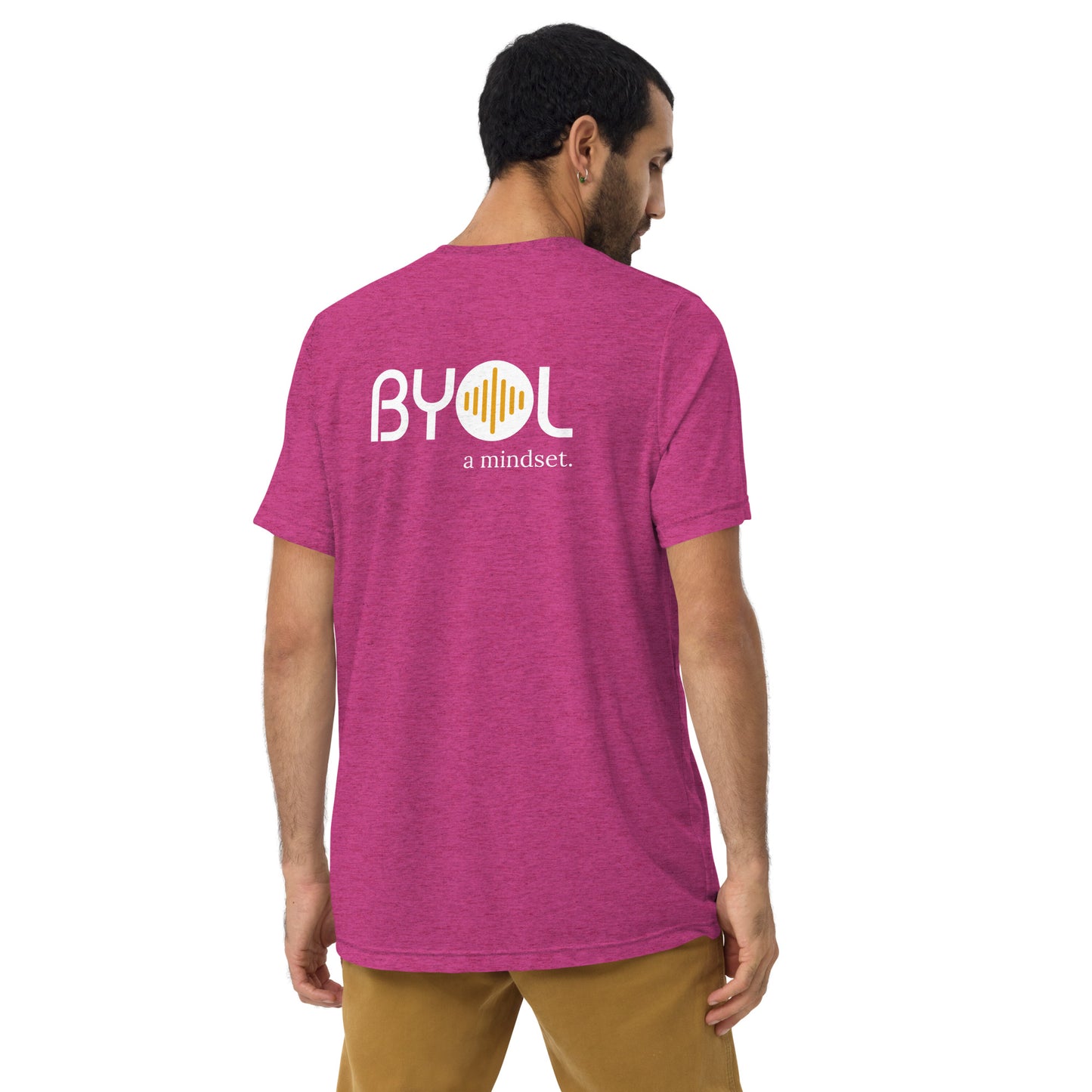 A young man with short dark hair wearing a berry tri-blend "BYOL: a mindset" T-shirt, viewed from the back. The T-shirt features the "BYOL" logo in white and yellow on the back and is available in multiple colors (black, red, gray, pink, beige, plus more) and sizes (S-3XL). The "be you out loud" logo is displayed at the top.